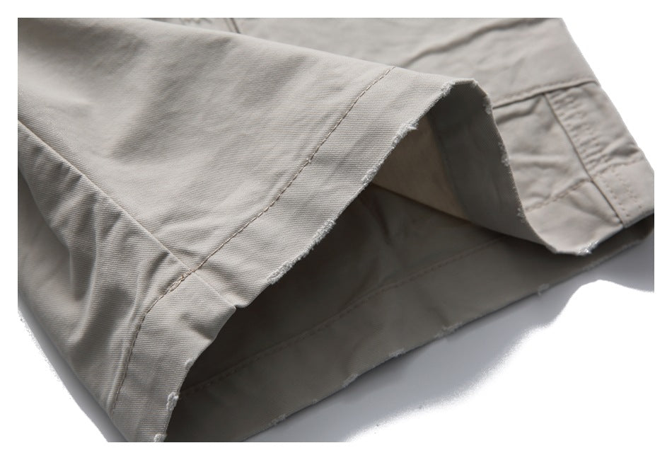Close-up of the wide hem opening on light taupe trousers, showing the inside and stitched edge.