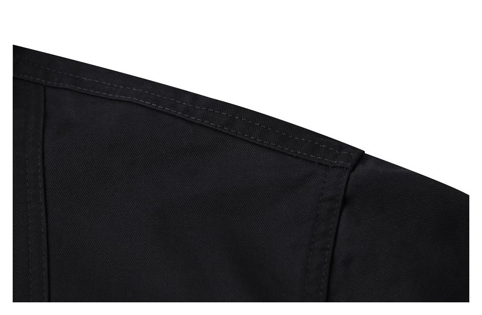 Close-up of black garment fabric with a curved stitched seam and intersecting panel seam.