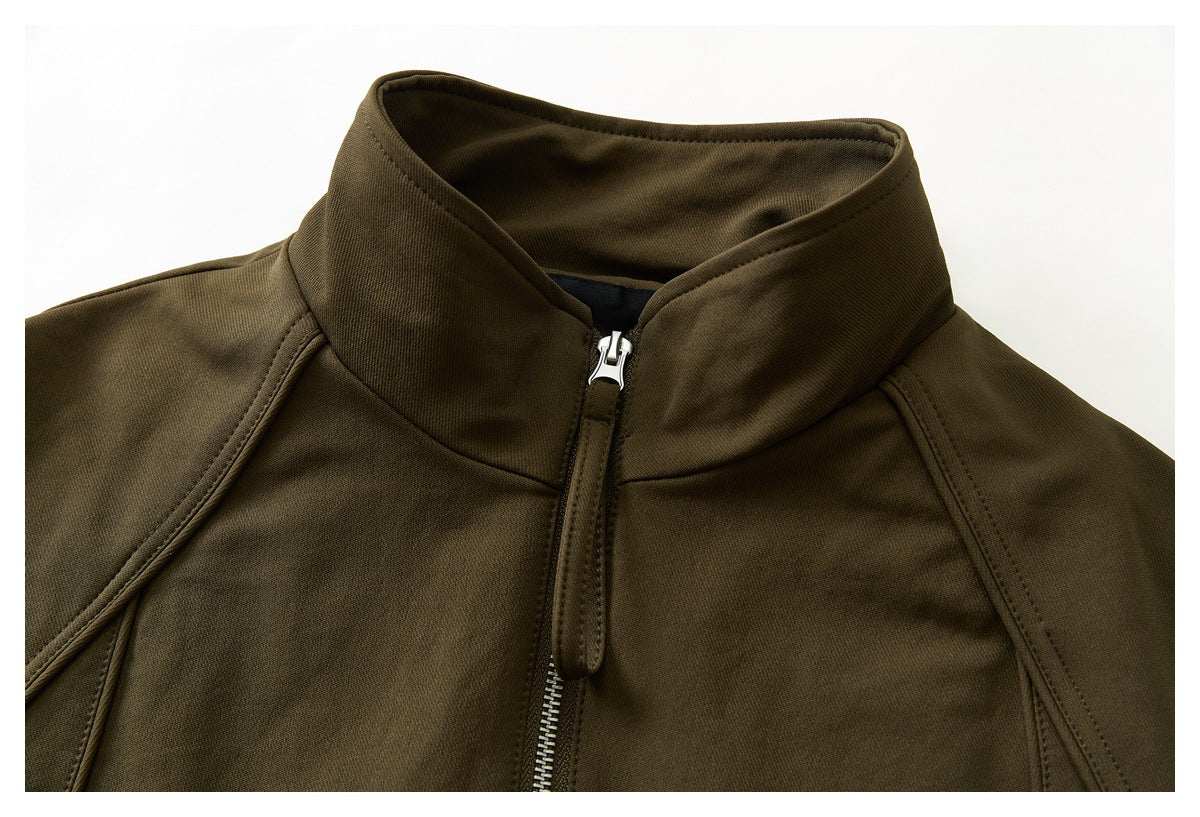 Close-up of an olive-brown jacket's tall collar, shoulder seams, and silver front zipper.