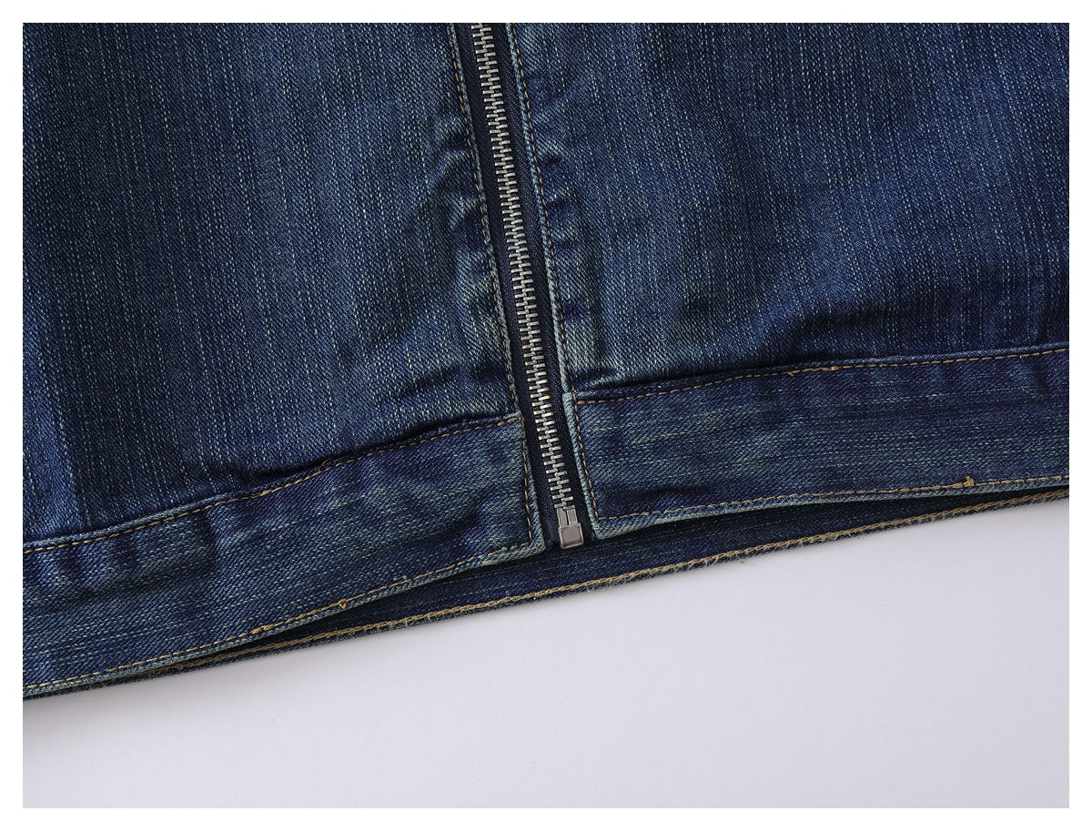 Close-up of the jacket's lower front zipper, hem, and double-stitched denim seams.