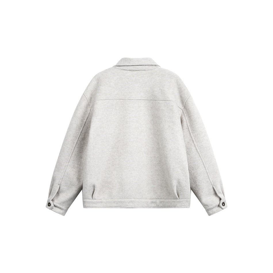 Back view of a light beige-gray collared jacket with long sleeves and buttoned cuffs, displayed flat.