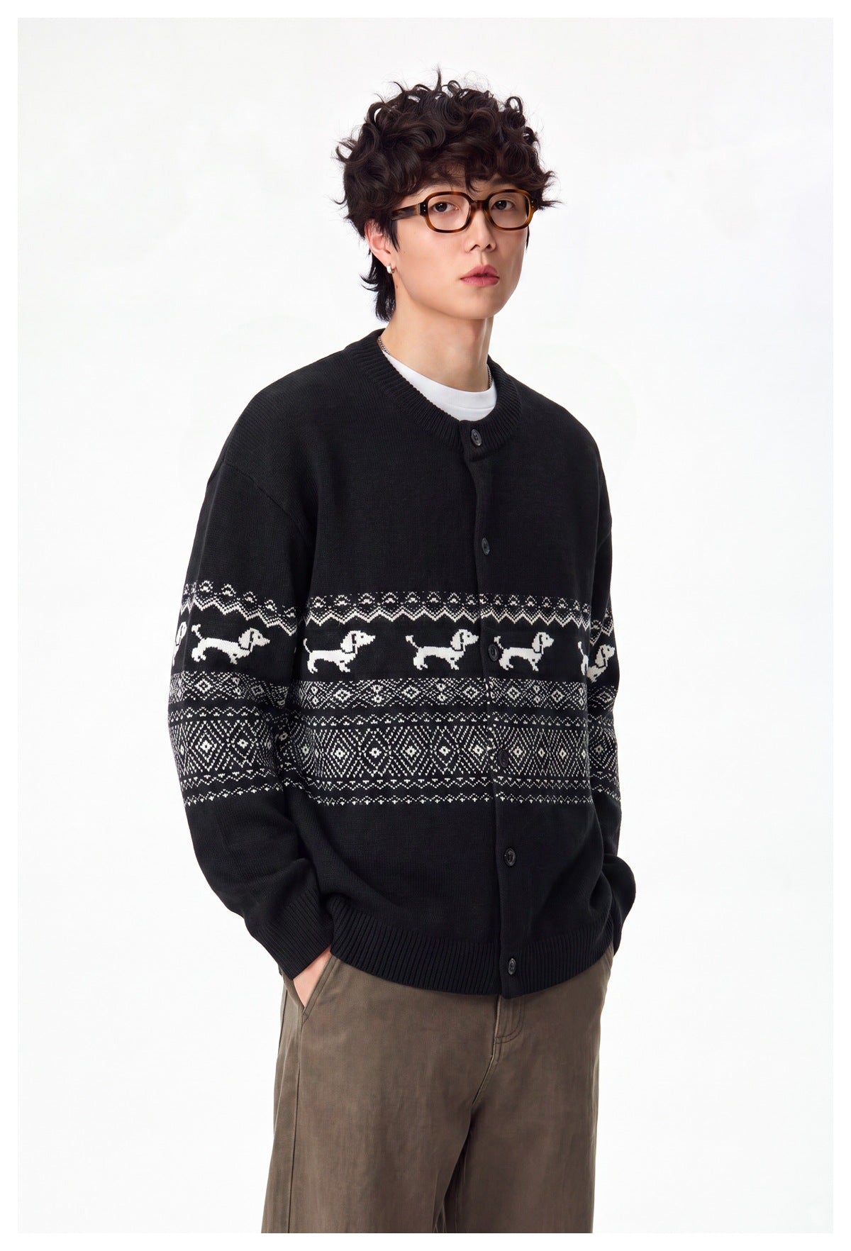 Three-quarter view of a model in a black cardigan with white dog motifs and geometric patterned bands.