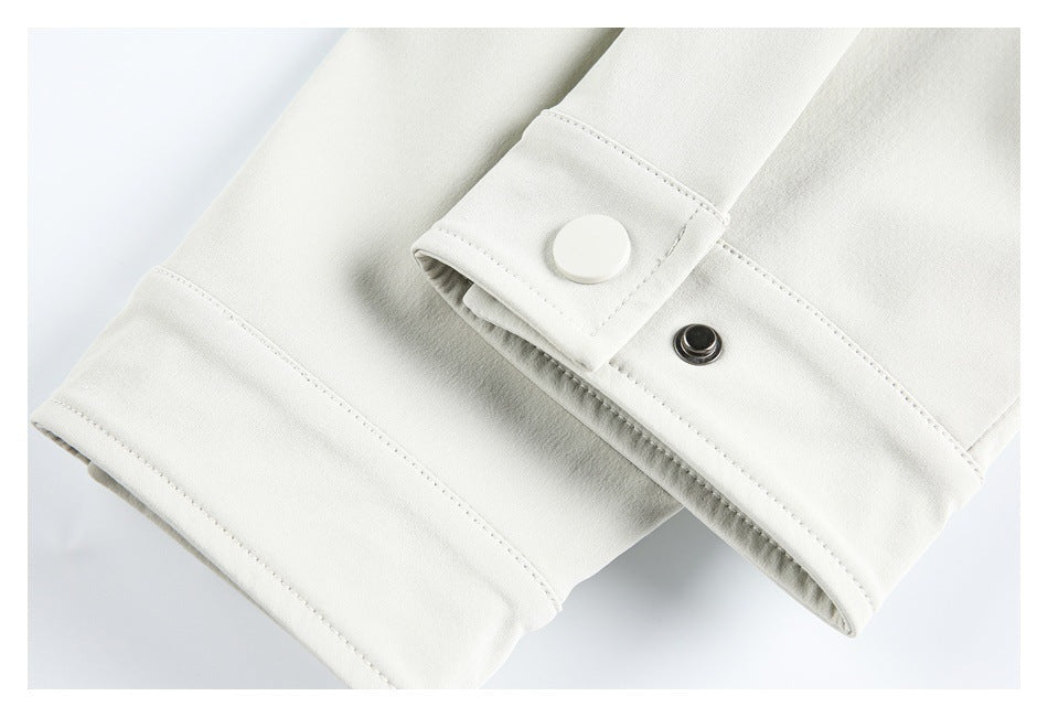 Close-up of a white garment cuff with a snap fastener and neat stitching.