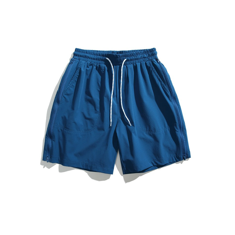Blue athletic shorts with an elastic waistband, white drawstring, side pockets and zippers at the hems, shown from the front.