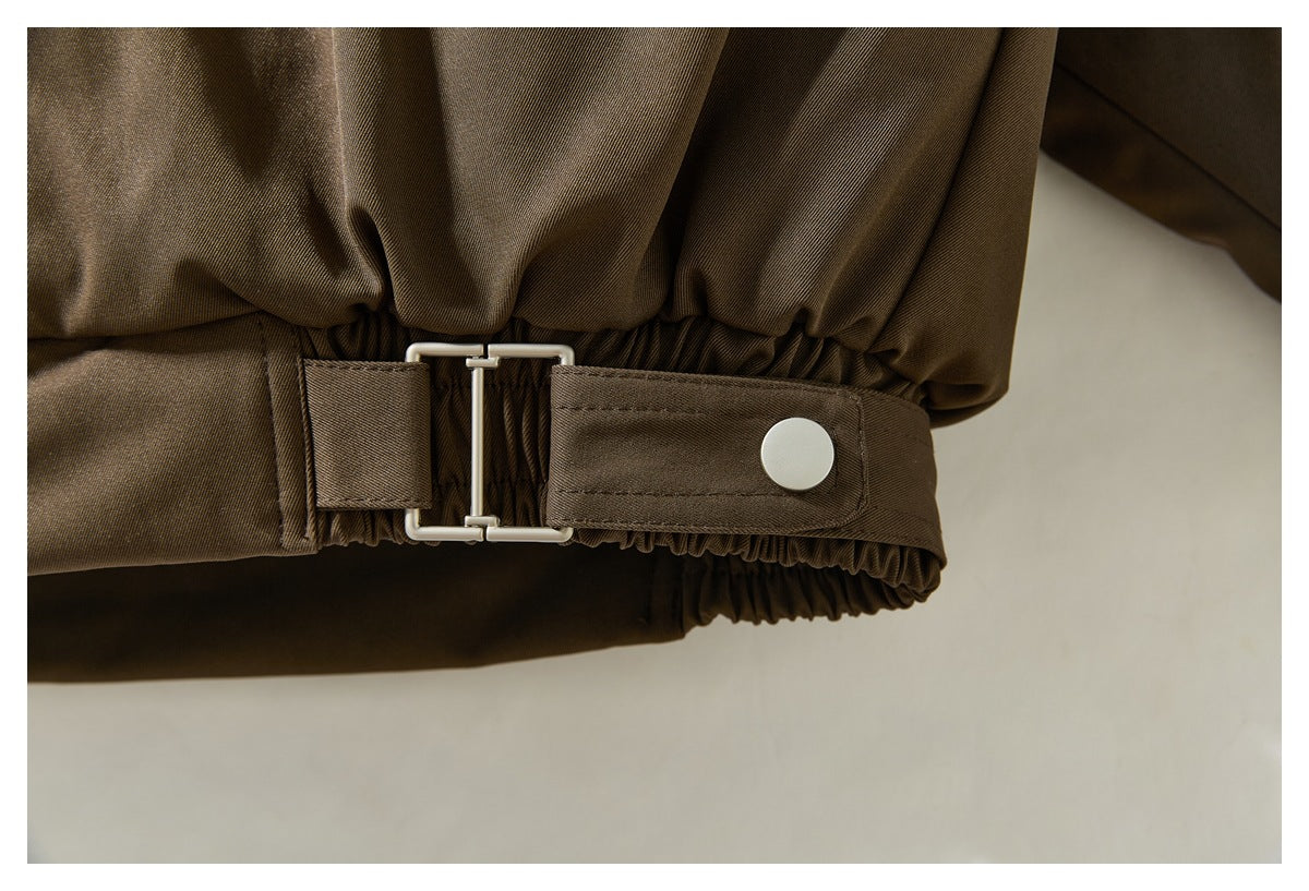 Close-up of the jacket’s gathered waist and adjustable snap-tab buckle.