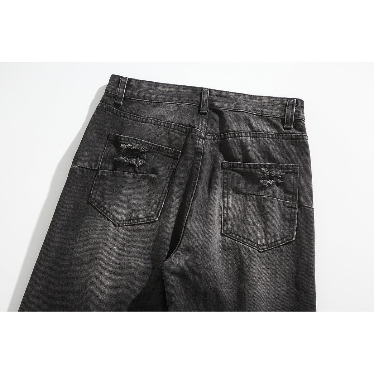 Back view of black washed jeans with two distressed rear pockets and belt loops.