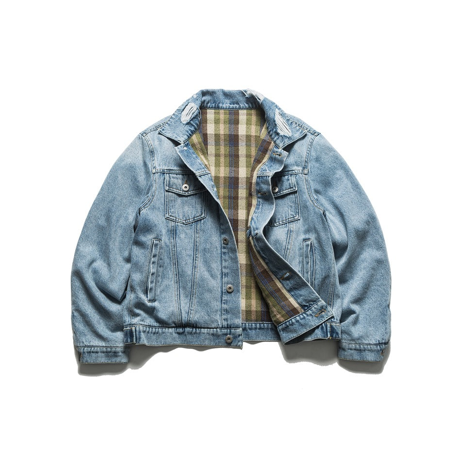 Blue denim jacket open to show green, tan and brown plaid interior and frayed collar