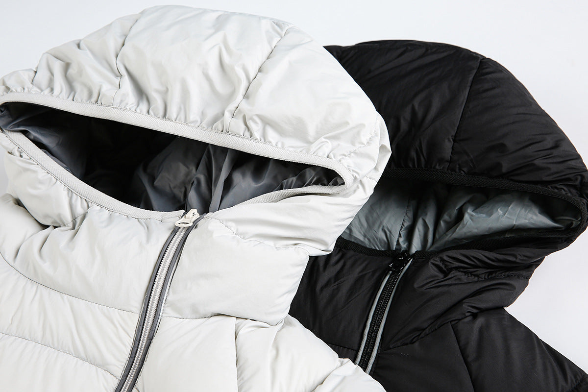 Close-up of white and black hooded puffer jackets showing the hood openings, lining, and front zippers.