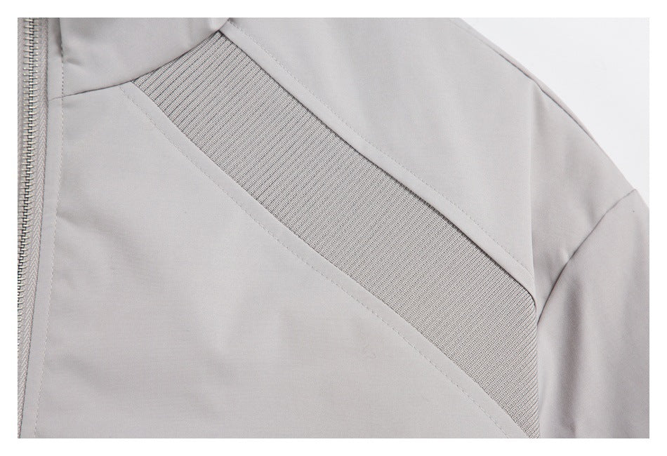 Close-up of a ribbed diagonal panel and seam on the light gray jacket.