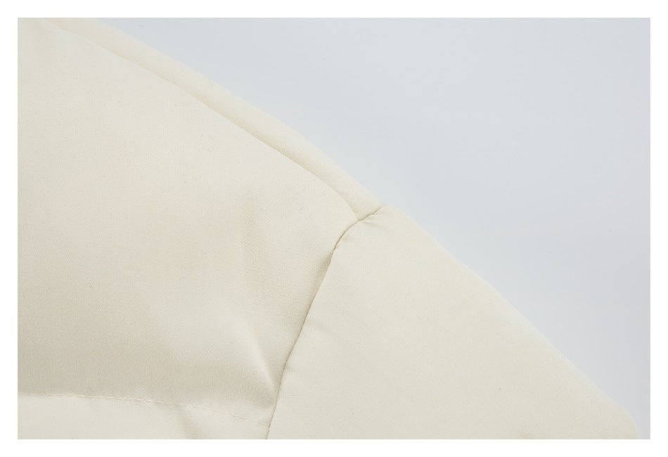 Close-up of the cream jacket's shoulder seam and sleeve construction.