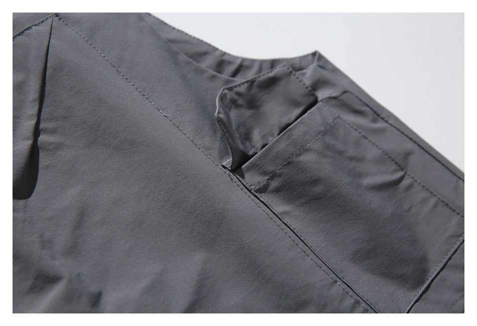 Close-up of a charcoal gray jacket collar and stitched chest pocket.