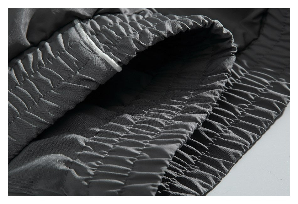 Close-up of the gathered elastic waistband on charcoal pants.