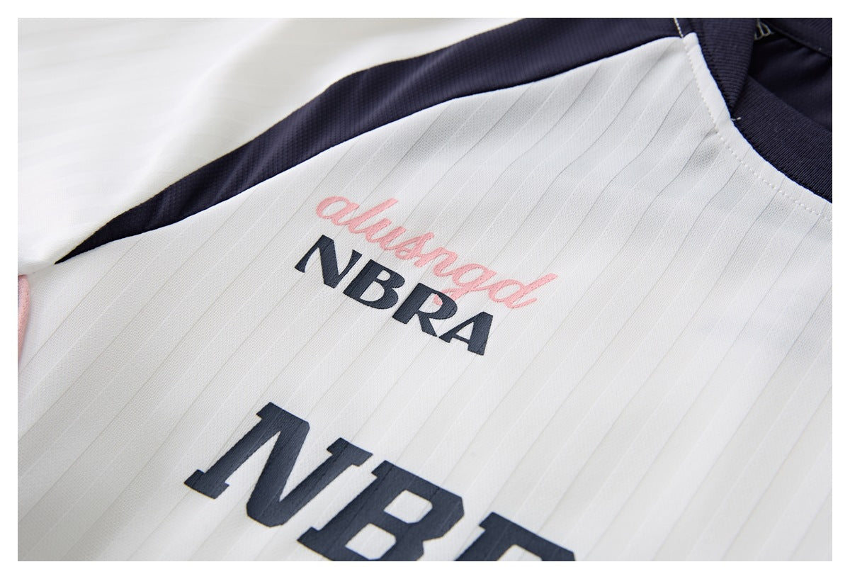 Close-up of a white pinstriped sports jersey with a navy collar and pink script above navy lettering.
