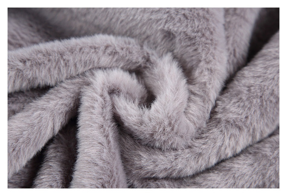 Close-up of gray plush fabric gathered into folds, showing its pile and texture.