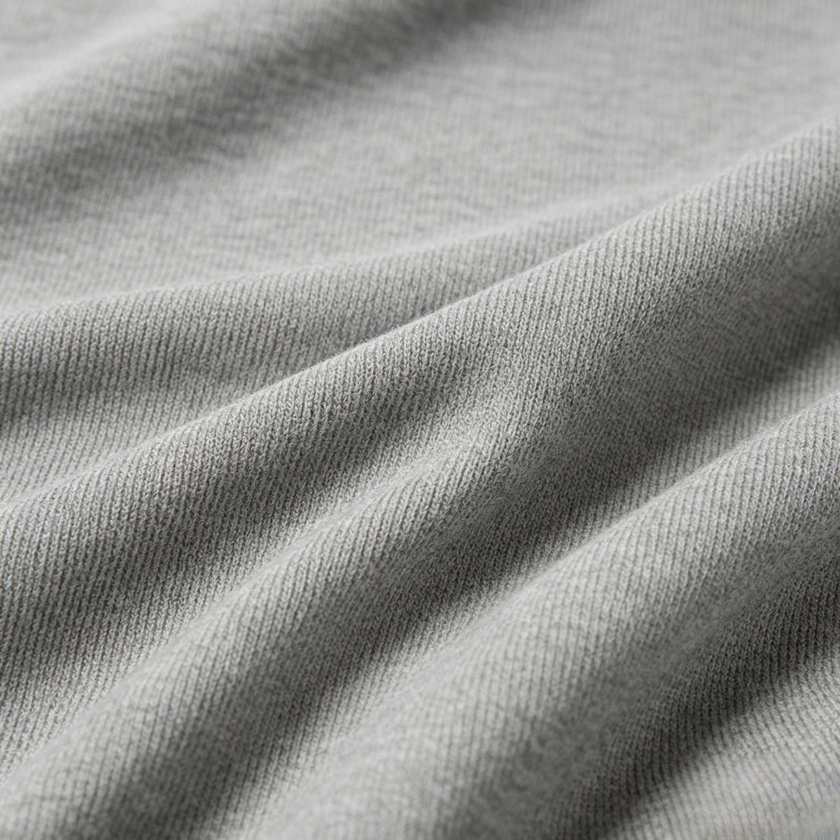 Macro view of gray ribbed fabric gathered into soft folds.