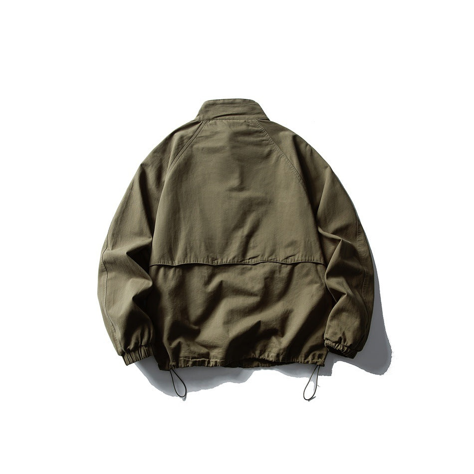 Back view of an olive jacket with a stand collar, raglan sleeves, elastic cuffs, and adjustable hem cords.