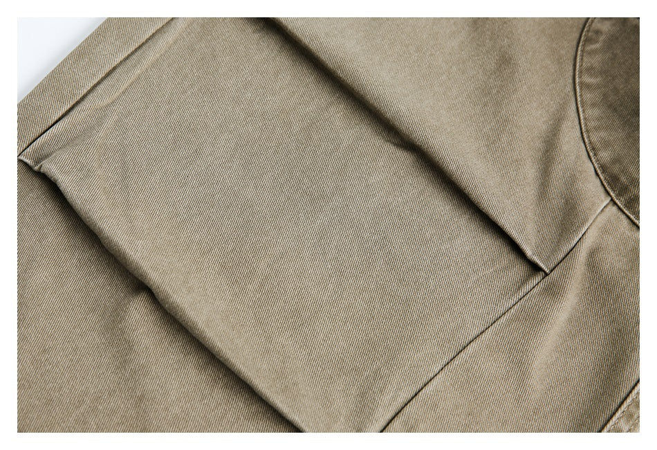 Close-up of taupe trouser panels and stitched seams.
