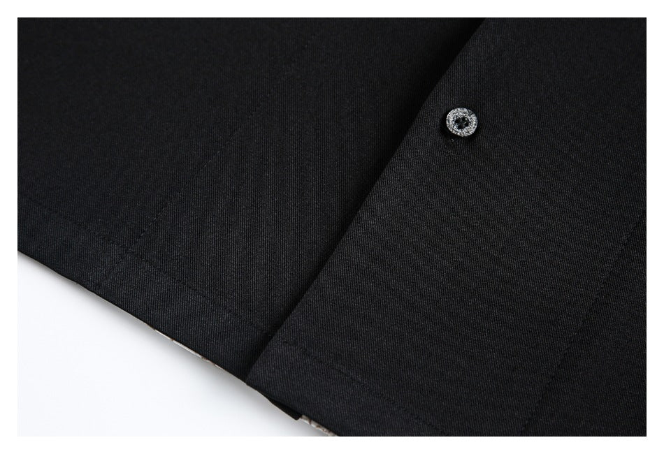 Close-up of the black garment hem and front placket, with one decorative button.