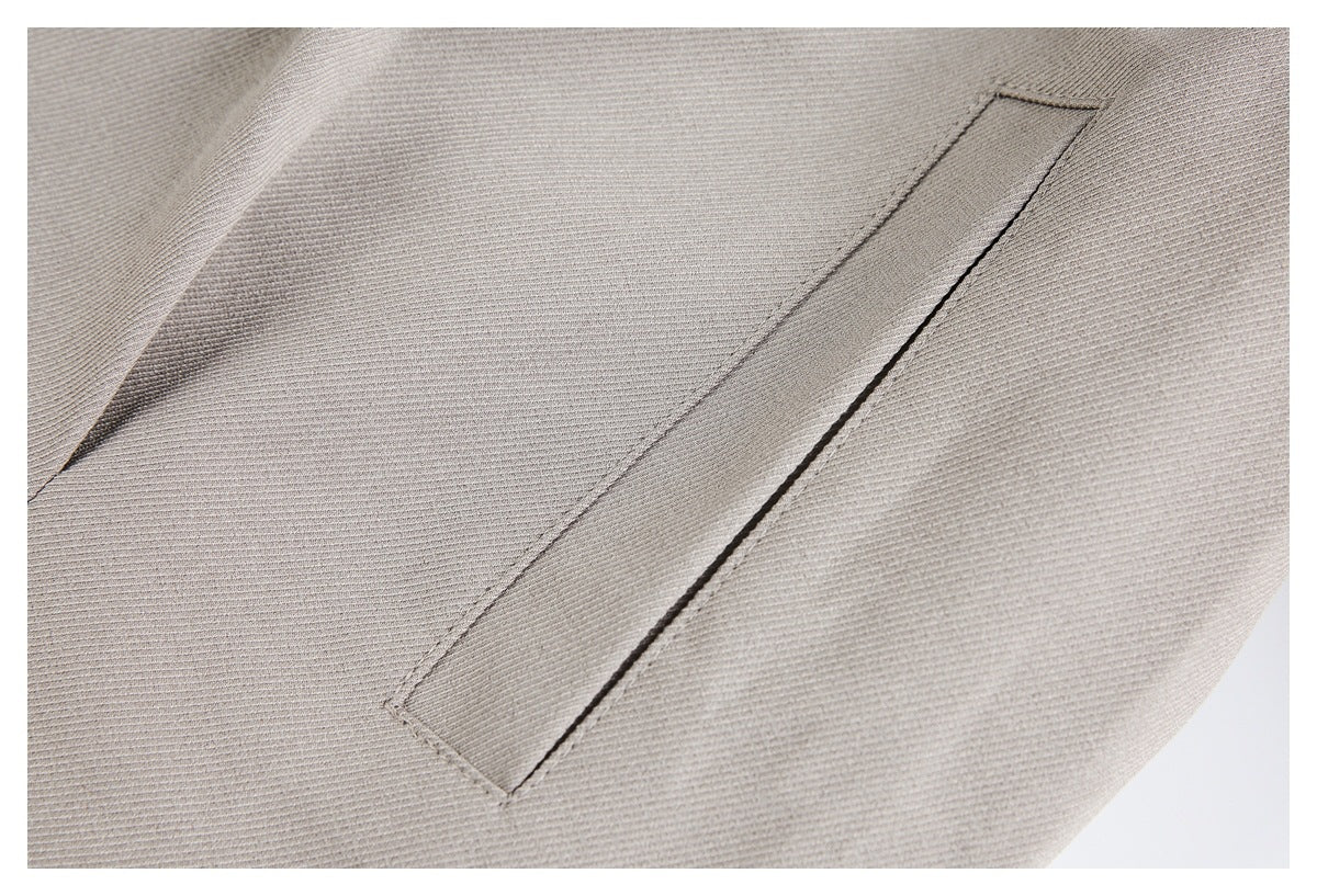 Close-up of a narrow welt pocket on light taupe fabric.