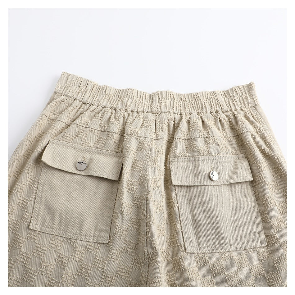 Close-up of the trousers' elasticized back waistband and two large flap pockets.