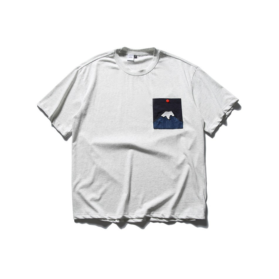 Gray crew-neck short-sleeve T-shirt with a mountain appliqué chest pocket, front flat lay