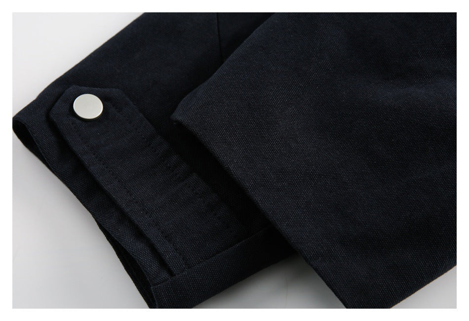 Close-up of a dark navy cuff with a round silver snap fastener.