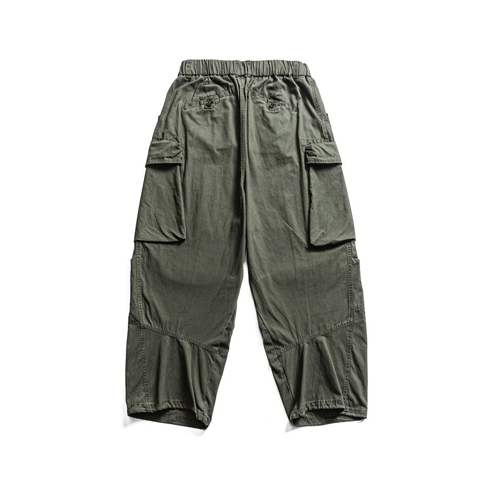 Back view of olive cargo pants with an elastic waist, two rear pockets, and large flap cargo pockets.