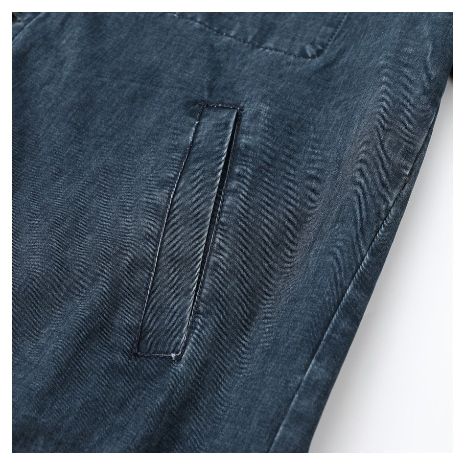 Close-up of a narrow welt pocket on dark blue denim, with a seam visible above it.