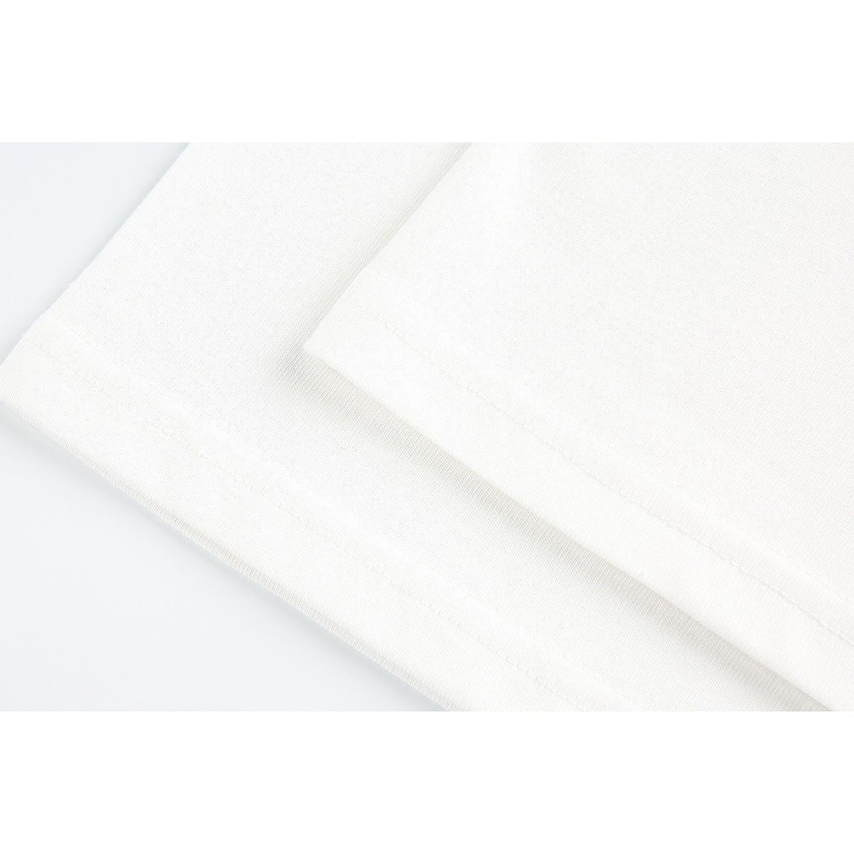 Close-up of white fabric edges and stitched hems.