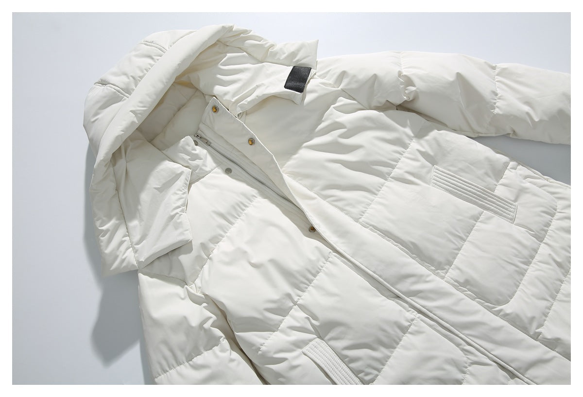 Close view of an ivory quilted jacket with hood, front zipper, snap-button placket and flap pockets.