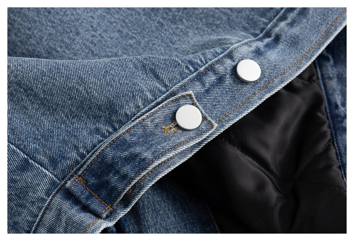 Close-up of silver snap buttons on the blue denim jacket over black quilted lining.