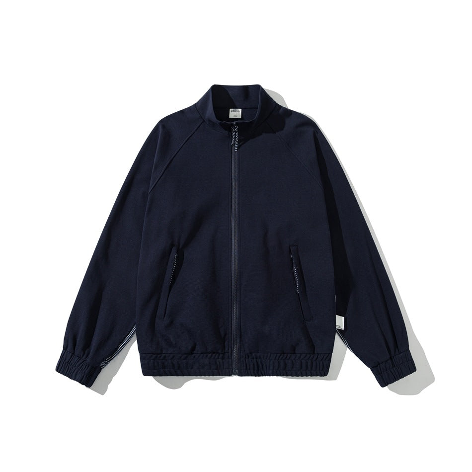 Navy zip-front stand-collar jacket with raglan sleeves, elastic cuffs and hem, striped pocket trim, flat lay