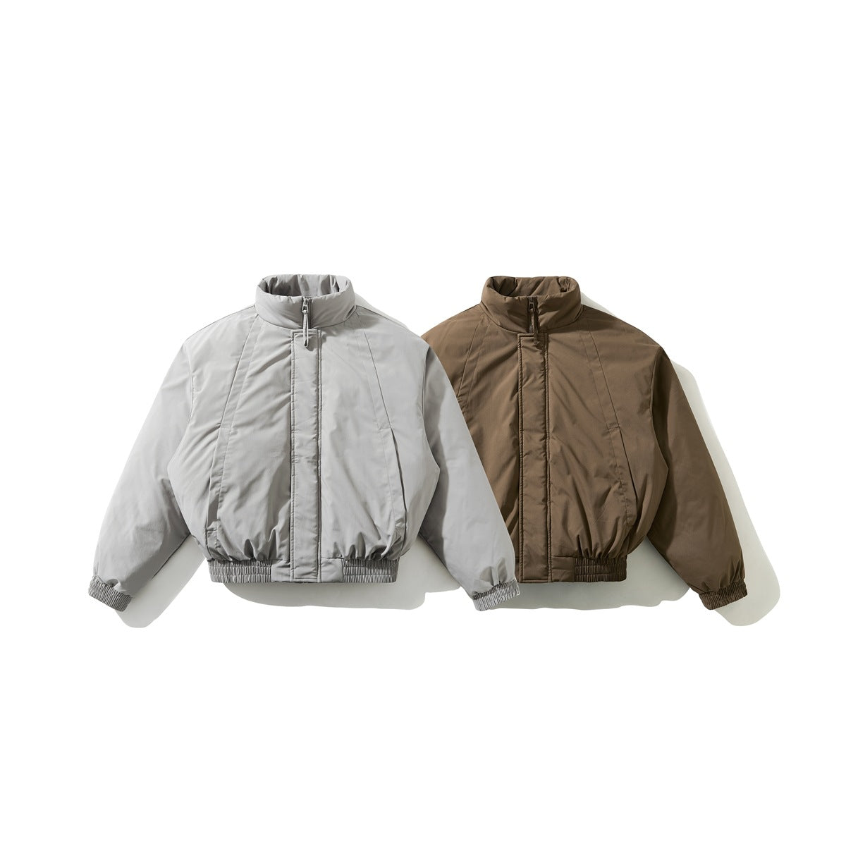 Front view of two cropped stand-collar jackets, one light gray and one brown, with zip fronts and elasticated hems.