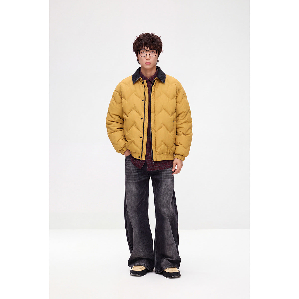 Model wearing a mustard-yellow chevron-quilted jacket with a dark contrast collar and snap front.