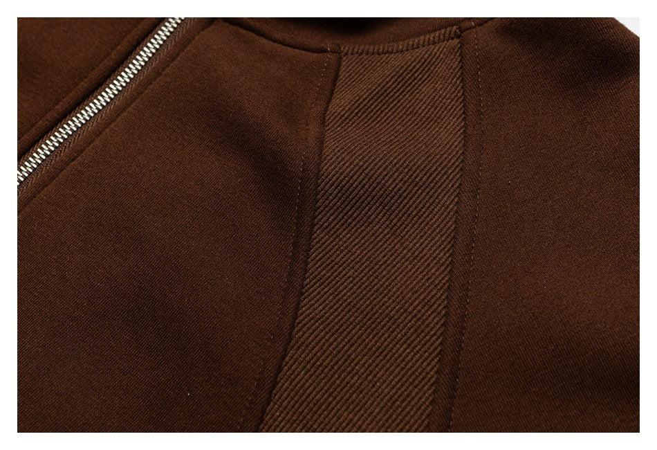 Close-up of brown sweatshirt construction, including a silver zipper and ribbed seam panel.