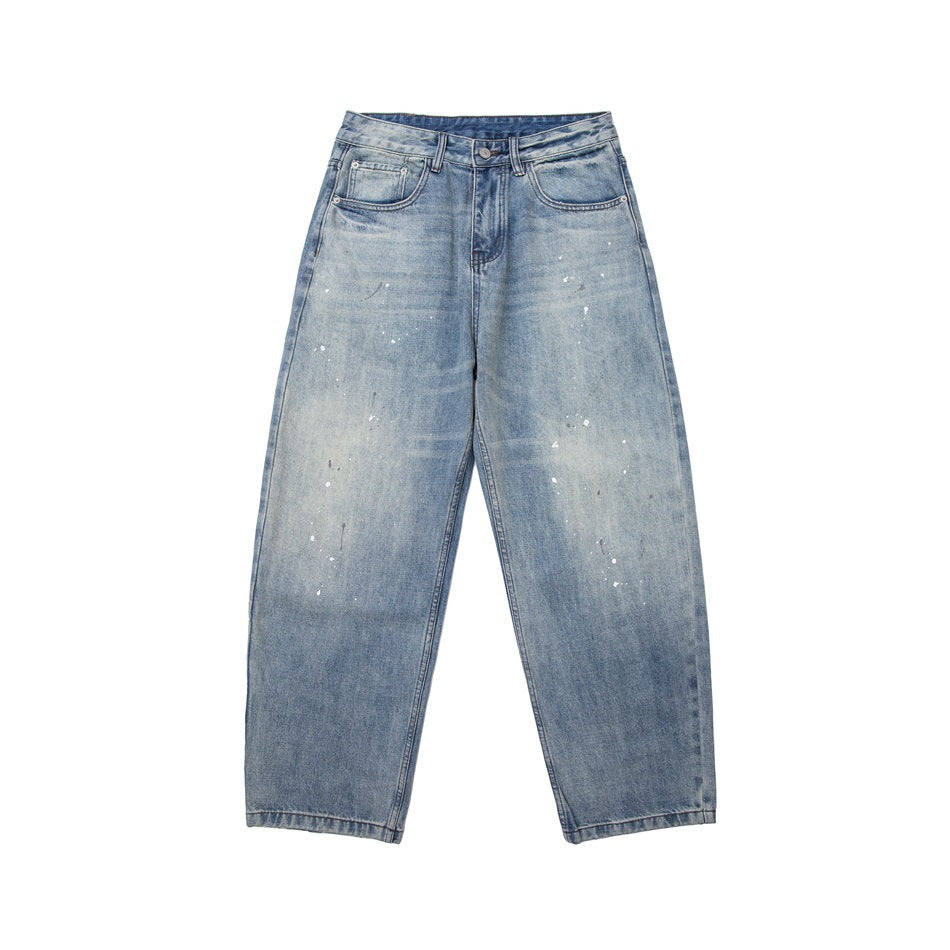 Front of light blue washed wide-leg jeans with white paint splatter and a button fly on a plain white background