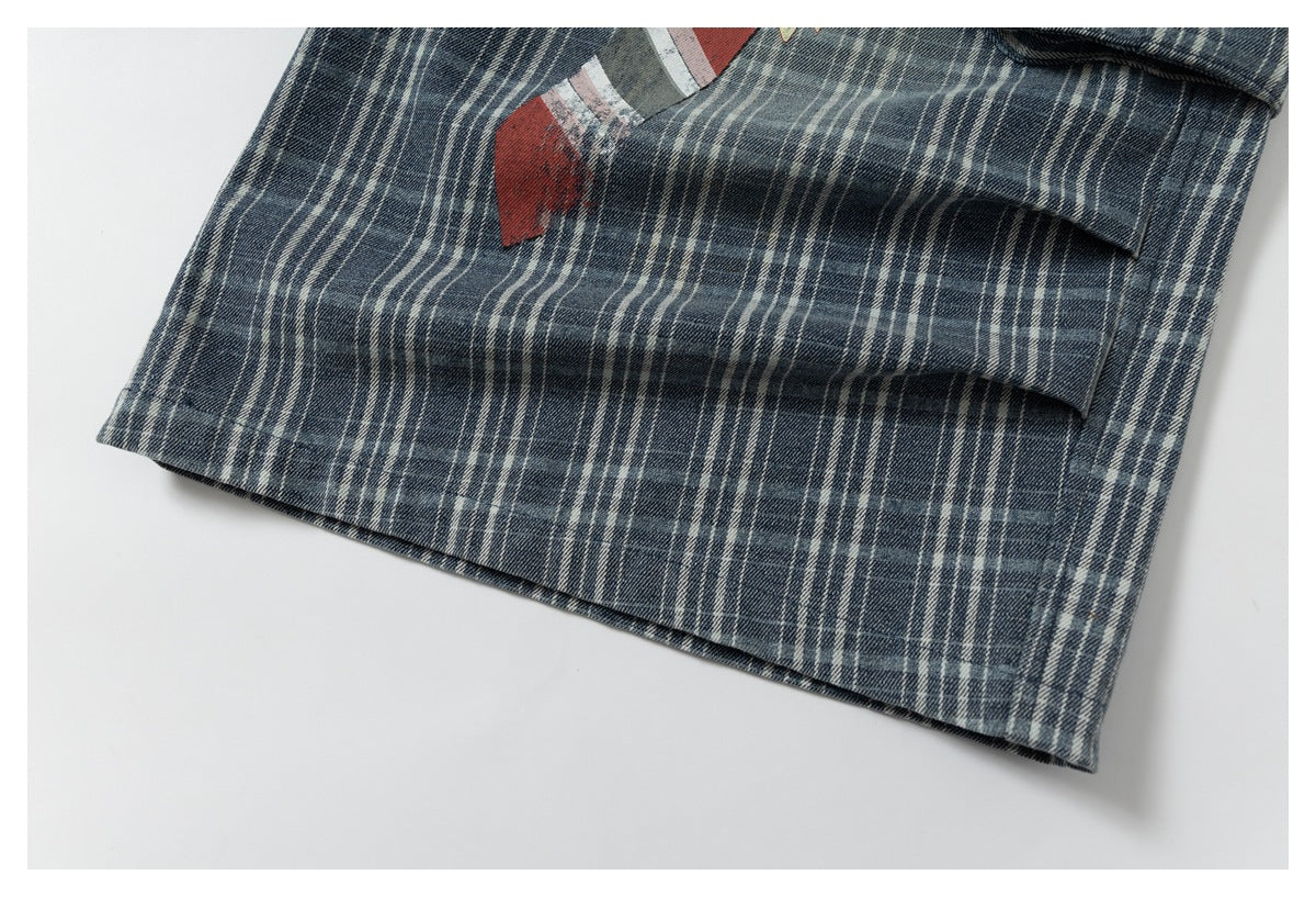 Close-up of the hem and pocket on dark blue and cream plaid trousers, with part of a red graphic visible.