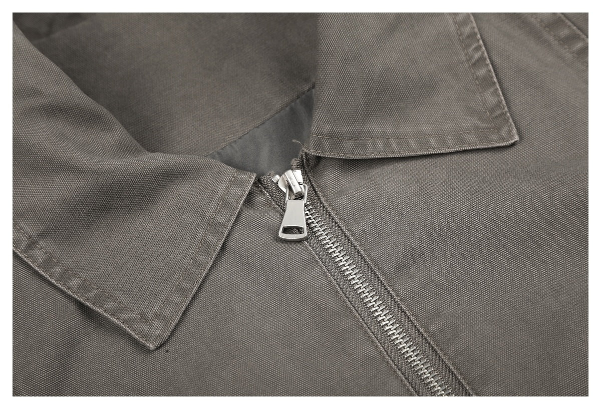 Close-up of a charcoal-gray collared garment with a silver zipper and textured fabric.