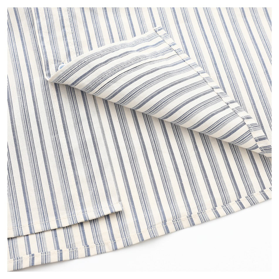 Close-up of a folded edge on a cream shirt with blue-gray stripes, showing stitching and the hem.