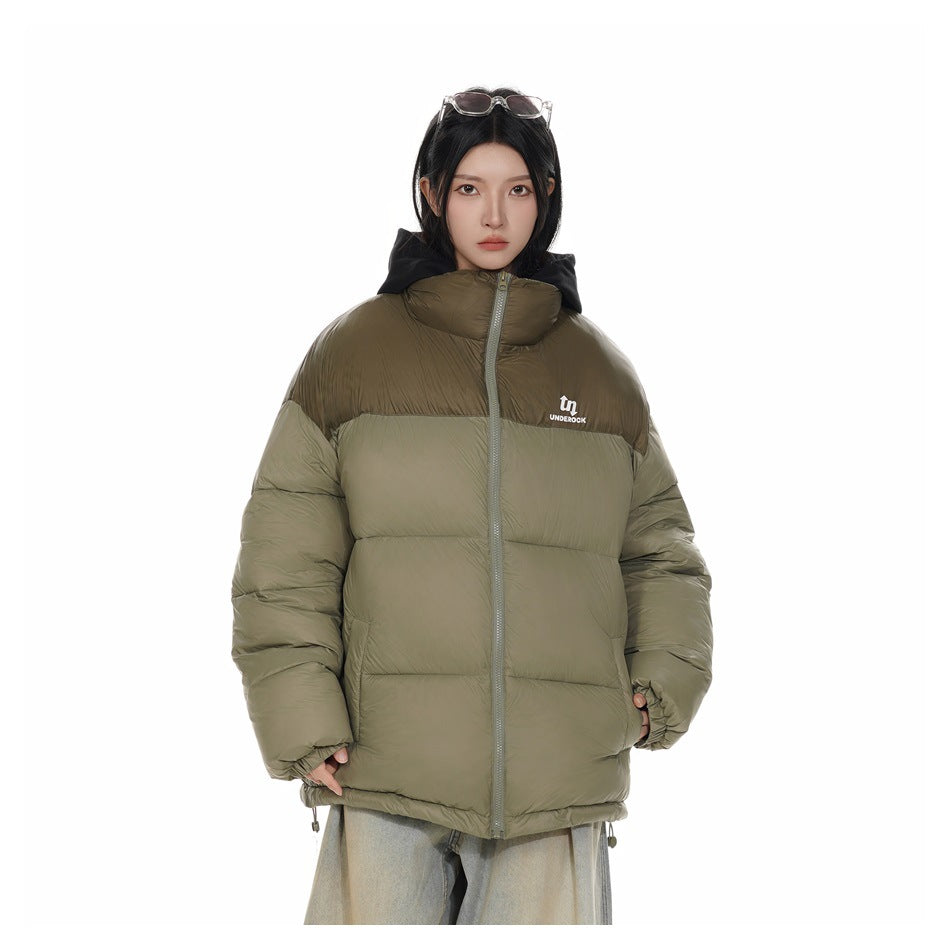 Model wearing a light army green puffer jacket zipped up with a stand collar and black hood, over light wash jeans