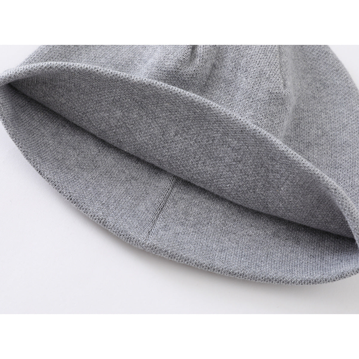 Close-up of the folded inner edge of a gray knit beanie.