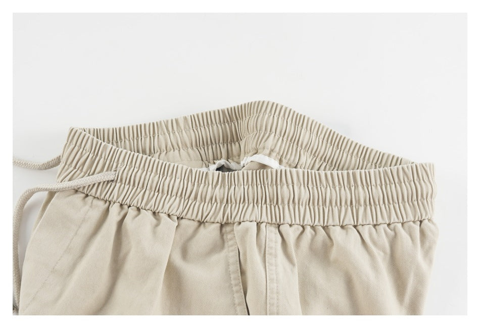 Close-up of the elastic waistband and inner construction of beige shorts.
