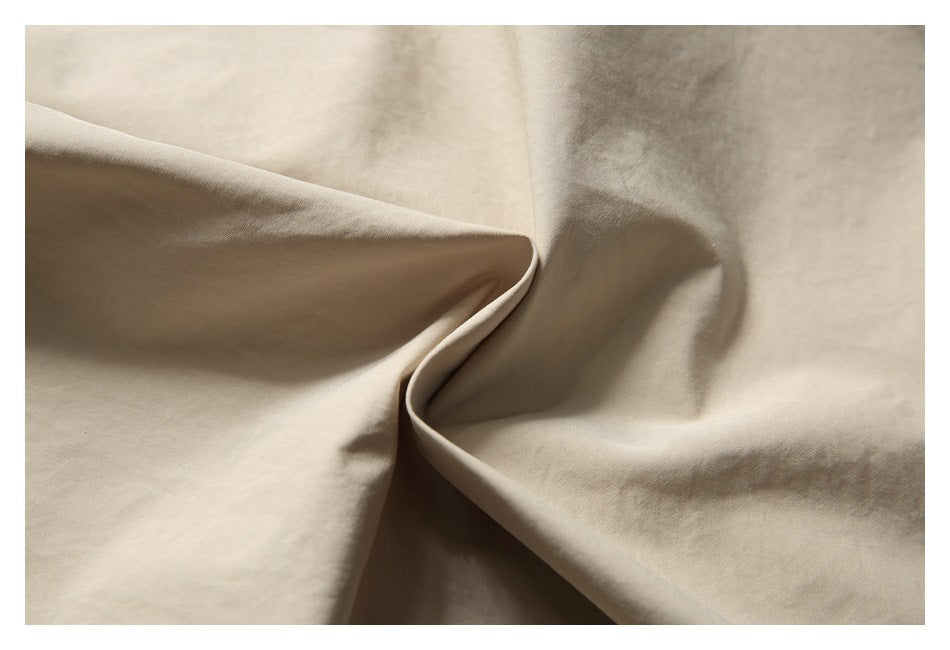 Close-up of beige fabric folded to show its surface and drape.