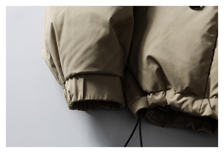 Close-up of the taupe jacket's elasticated cuff and gathered hem with a hanging drawcord.