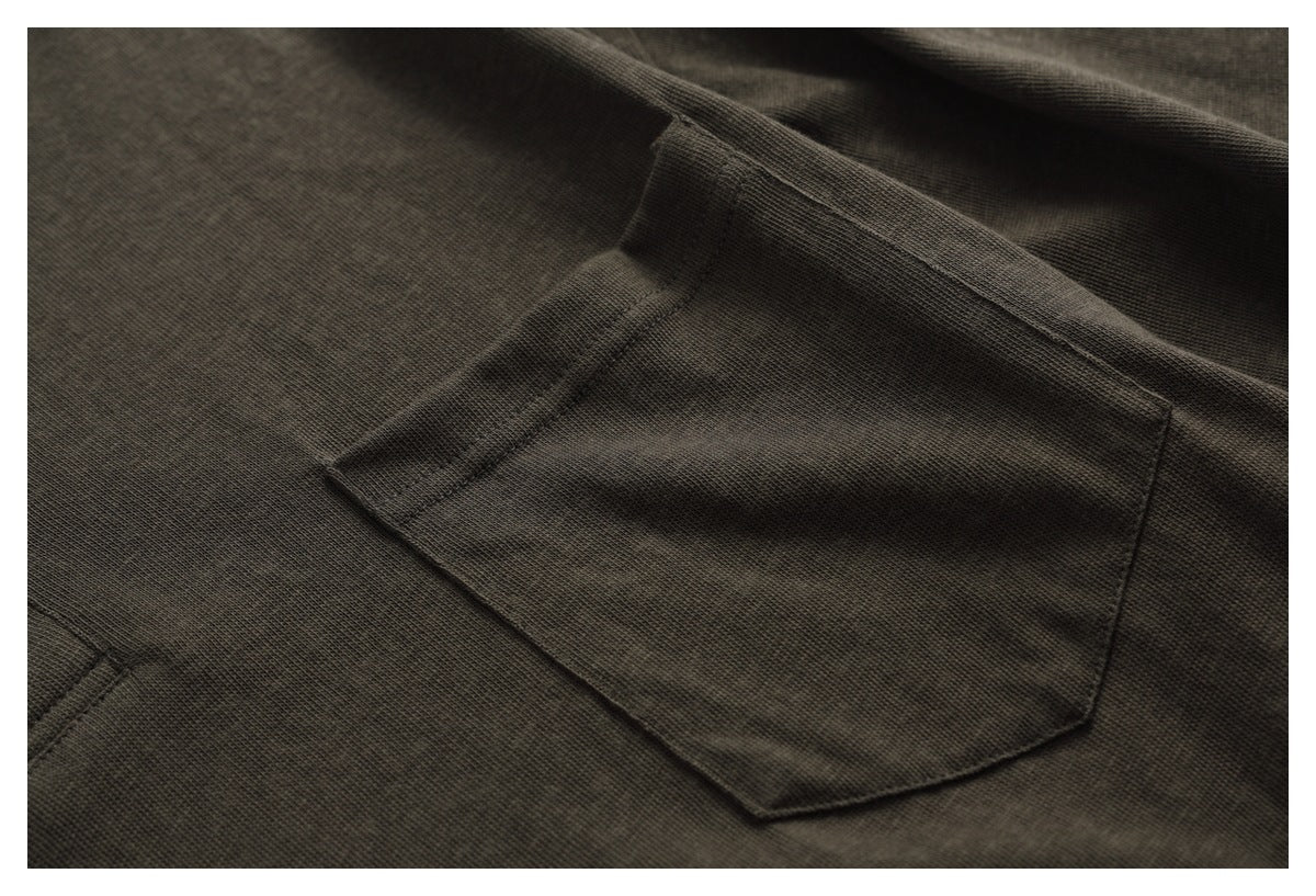 Close-up of a stitched chest pocket on dark olive-brown shirt fabric.