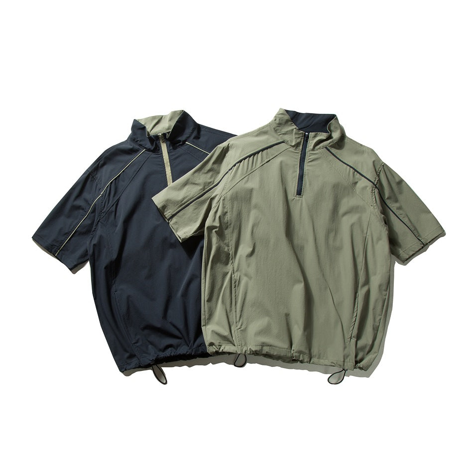 Two short-sleeve quarter-zip pullovers in olive and navy, with raised collars, contrast piping, and adjustable hems.