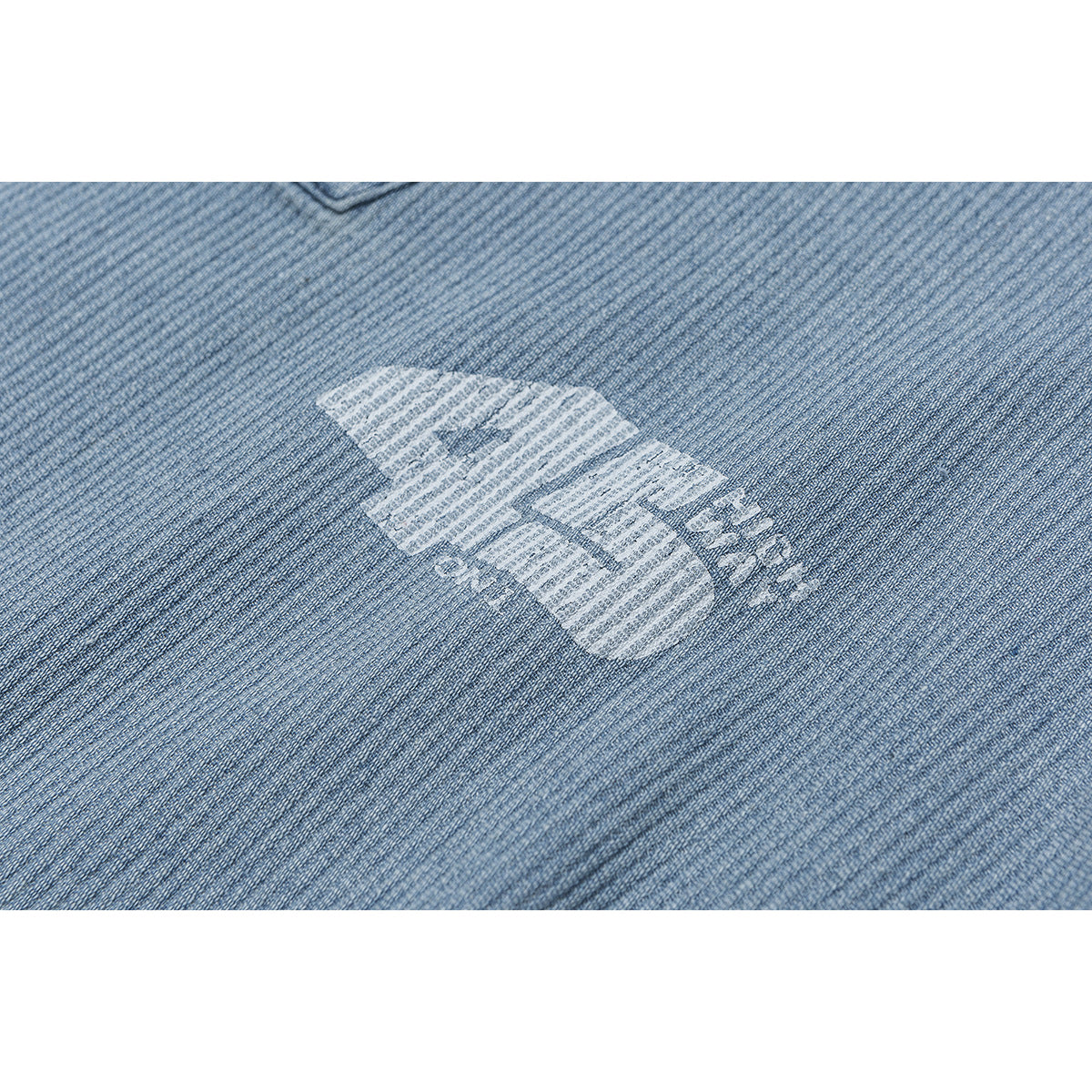 Close-up of a white graphic printed on light blue textured jacket fabric.