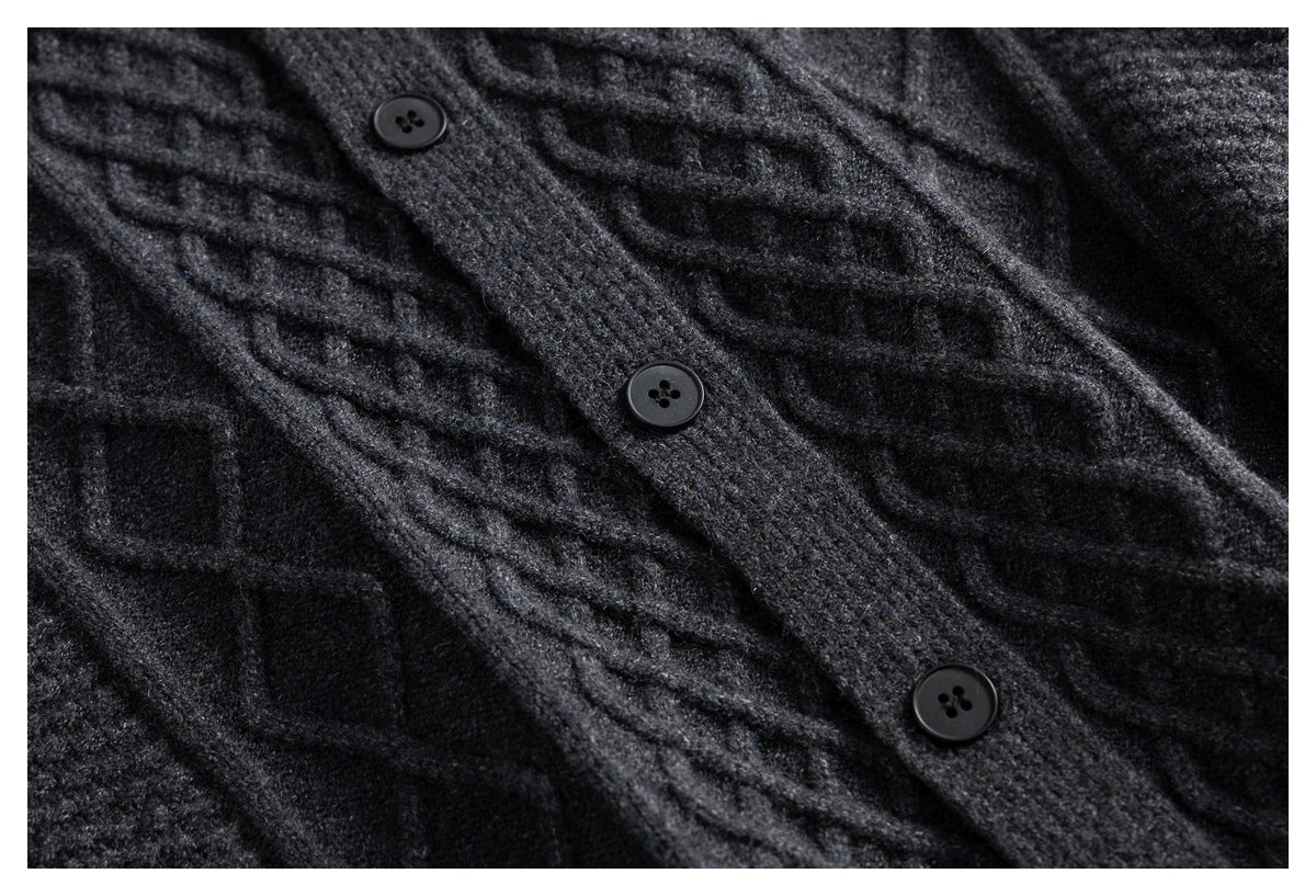 Close-up of three dark buttons along the placket of a charcoal gray cable-knit cardigan.