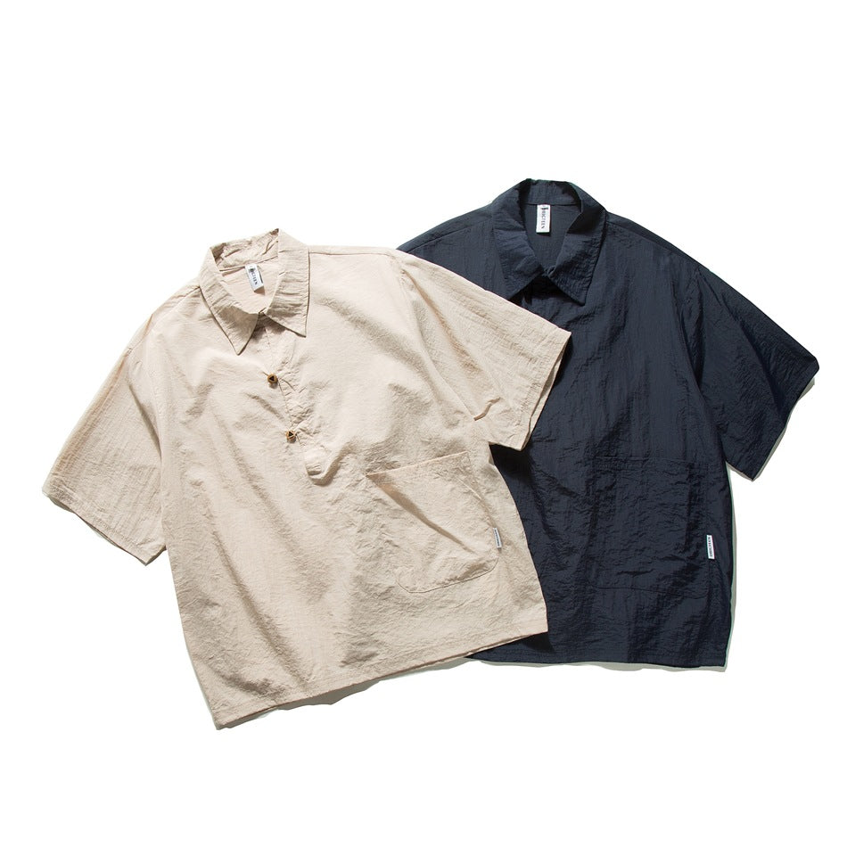 Two short-sleeve collared shirts shown flat: beige in front and dark navy behind, each with a chest pocket.