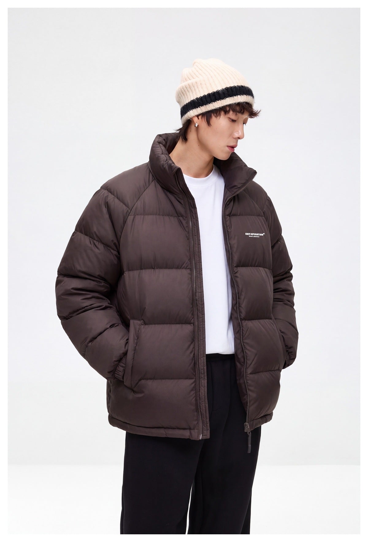 Model in a dark brown quilted puffer jacket, shown at an angle with its high collar, zip front and side pockets.